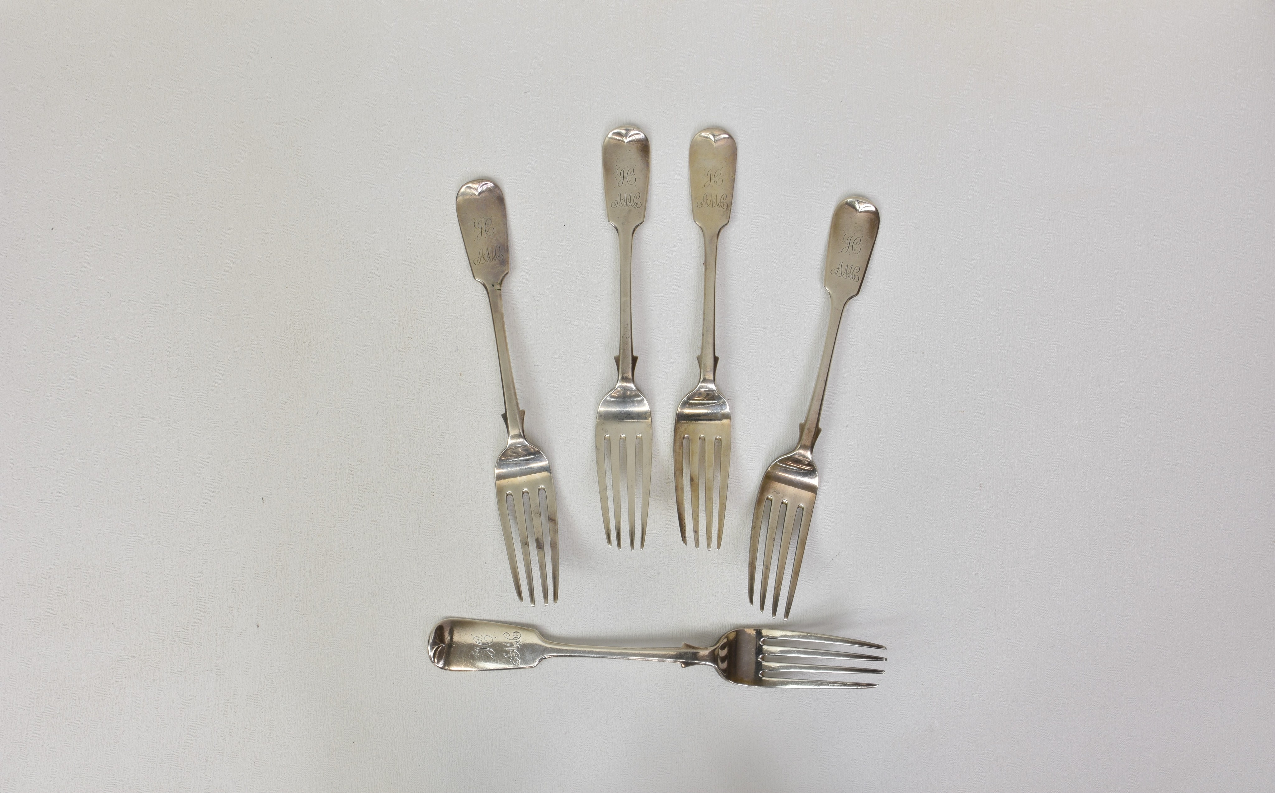 Five Channel Island Victorian fiddle pattern silver table forks, over stamped maker's mark 'J.P.