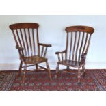 Two Victorian beech and oak lath back kitchen armchairs, with solid seats and shaped arms, on turned