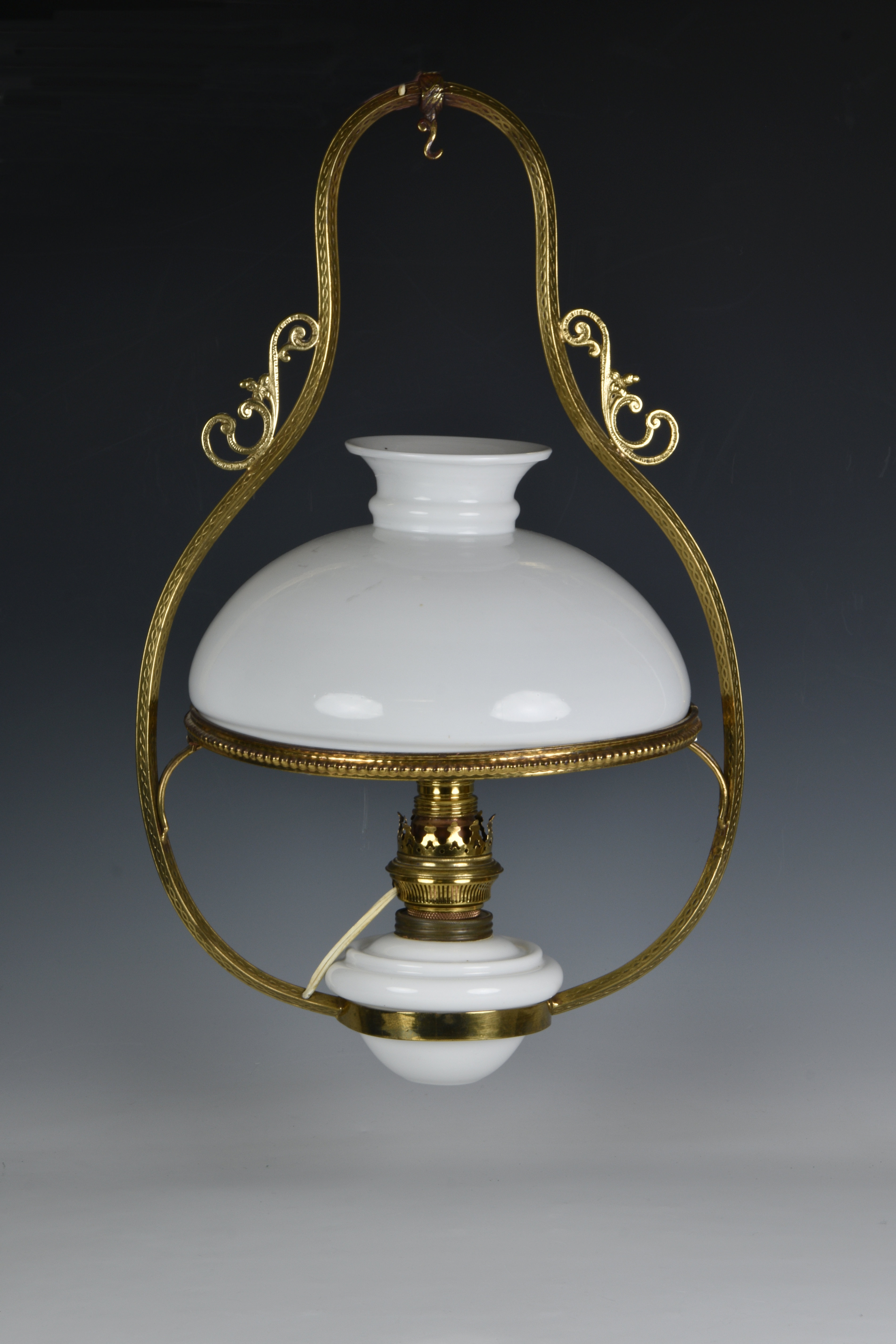 A 19th century style brass ceiling oil lamp, 20th century, fitted for electricity, with white milk