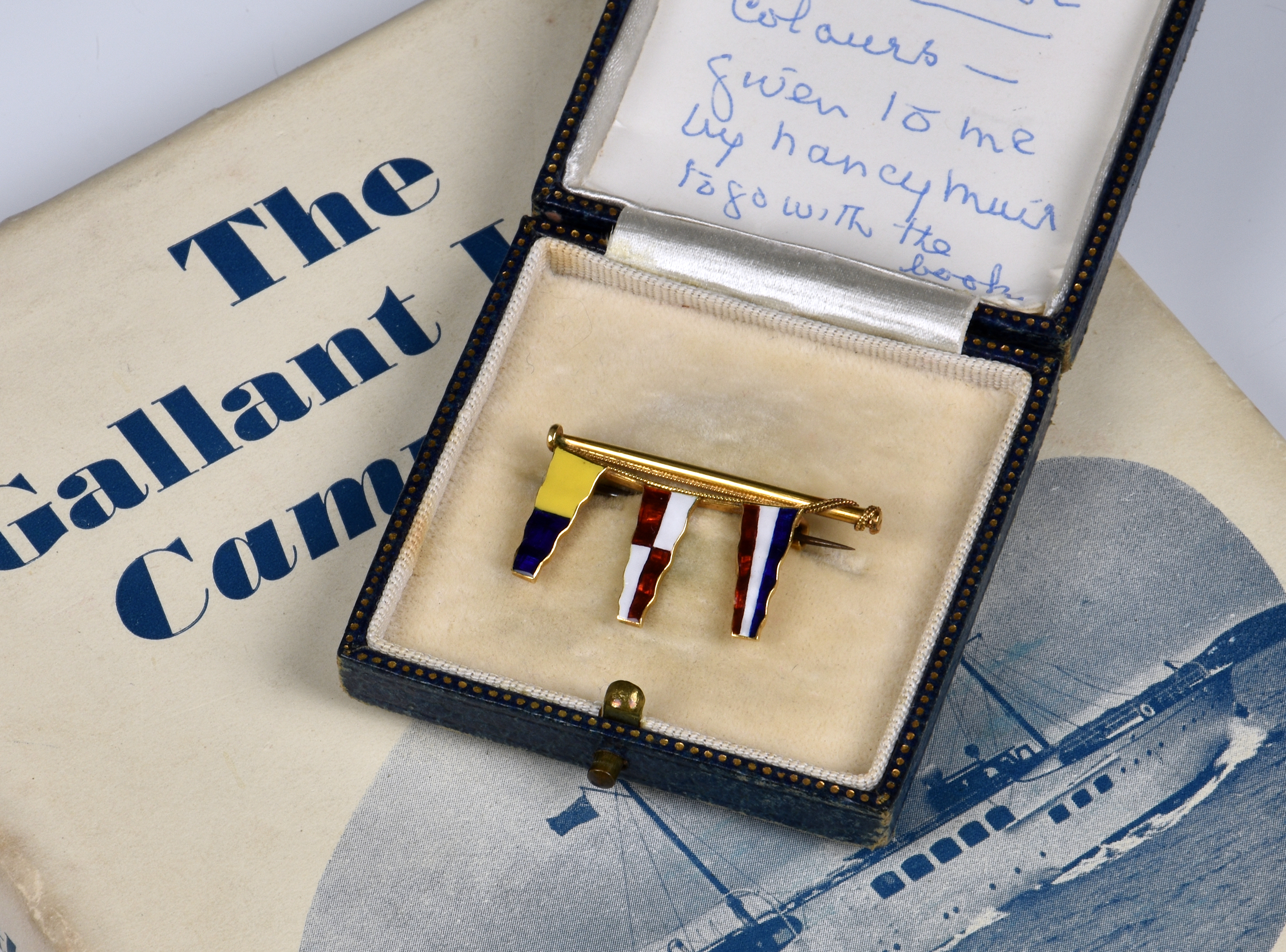 A boxed 18ct Gold Brooch in the form of a pole with three enamel pennants, stamped 'Benzie Cowes',