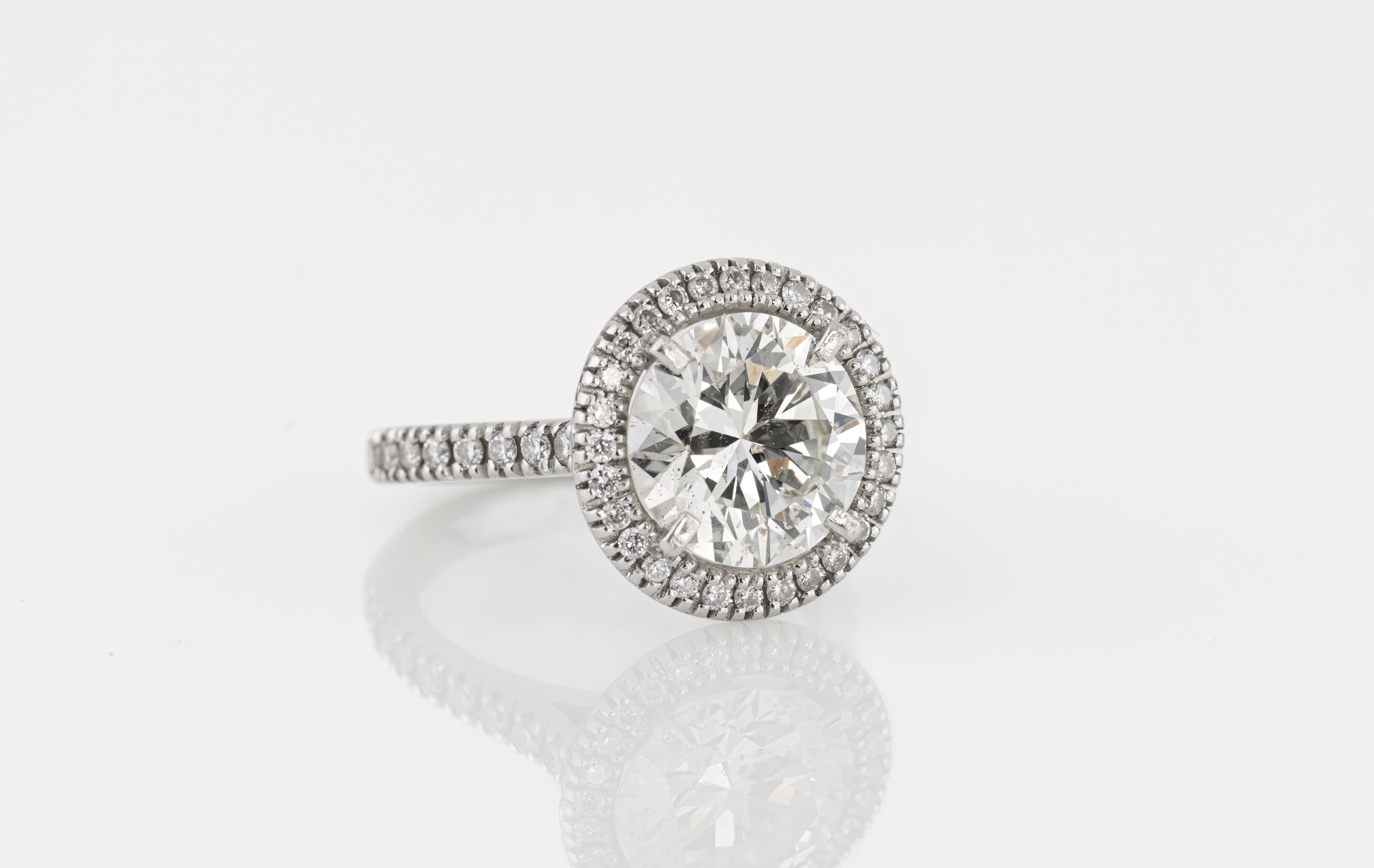 A fine platinum and diamond halo cluster ring, the principal brilliant cut diamond originally from