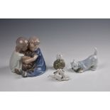 A Royal Copenhagen porcelain figure group, depicting a pair of seated children cuddling a puppy, No.