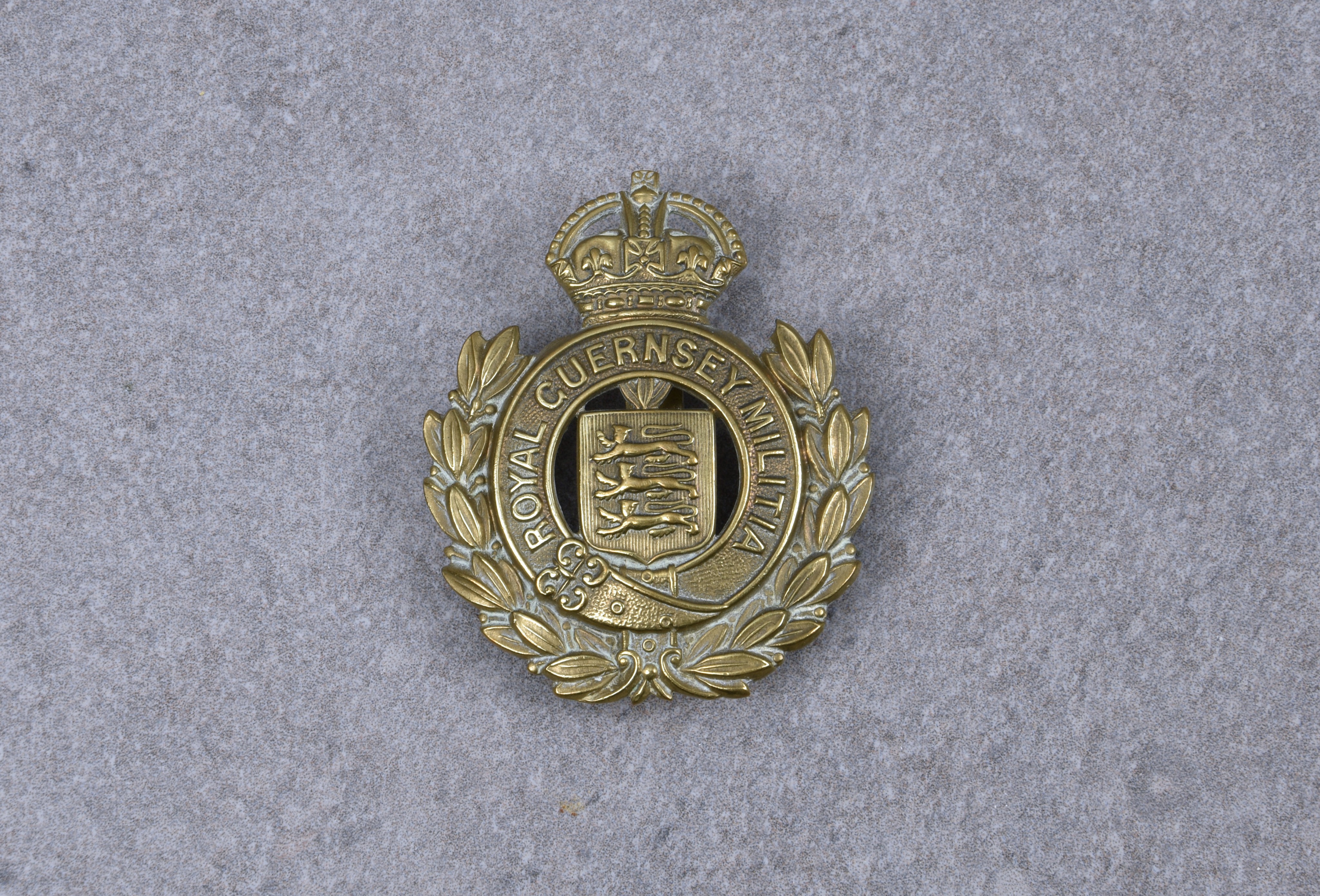 Royal Guernsey Militia Channel Islands cap badge, circa 1925-40, die-stamped brass crowned title