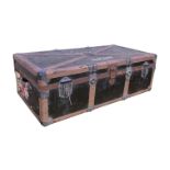 A vintage cabin trunk, early 20th century, with broad reinforcing leather strips and multiple locks,