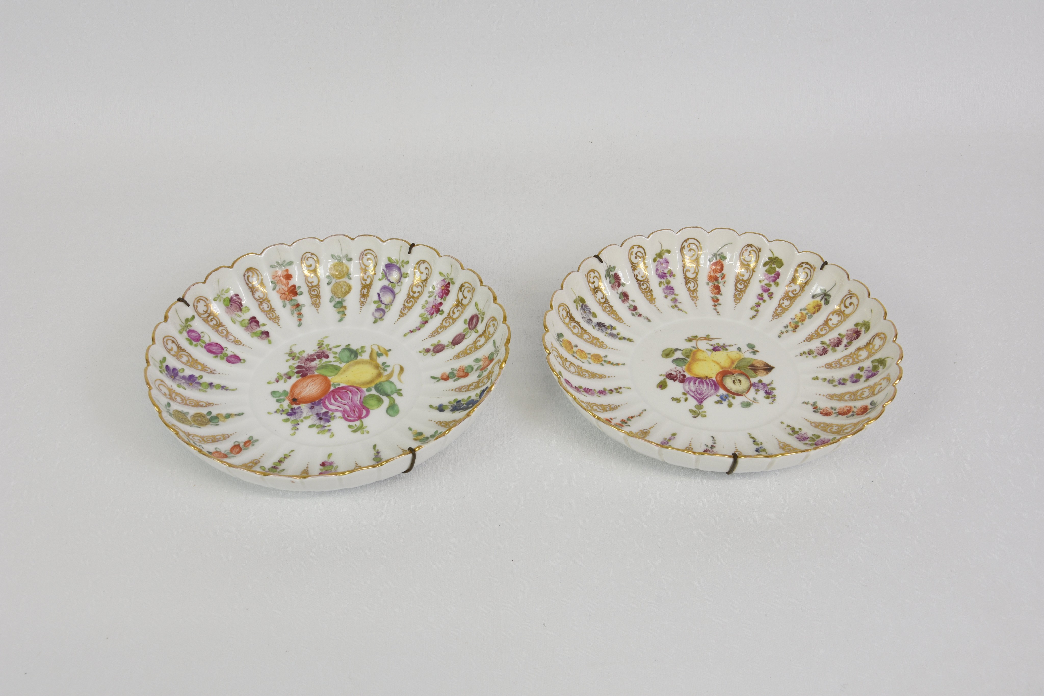 Two Meissen fruit decorated shallow bowls, with multi lobed, fluted sides, alternate flutes with