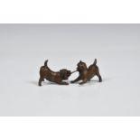 A miniature bronze of two Cairn Terriers, late 20th century, tusselling over a stick, mid-brown