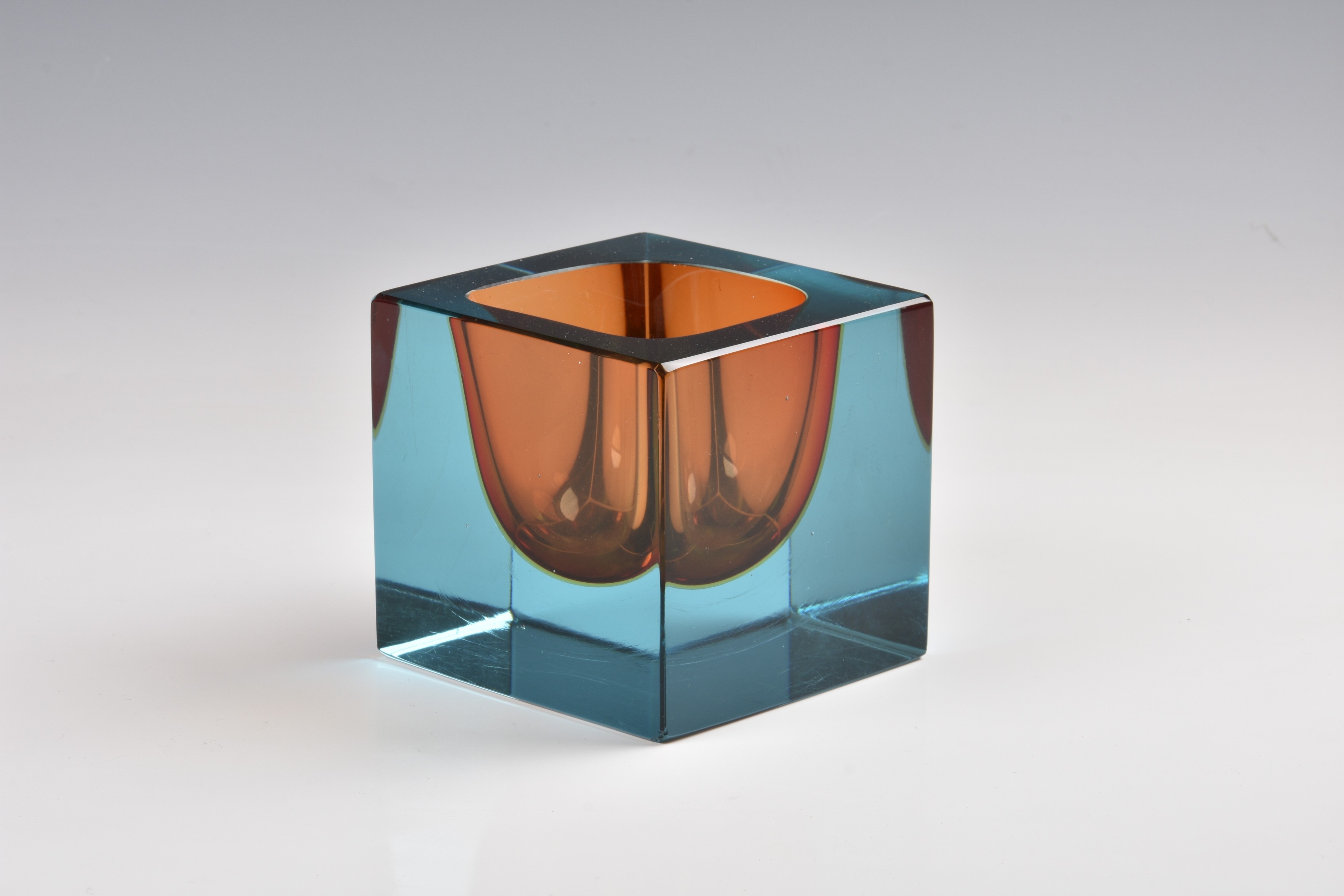 A 1960s square art glass paperweight style vase, in blue and orange, 3¾in. (9.5cm.) high.. *