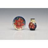 A miniature Moorcroft Pottery vase and dish, varying marks to bases, floral decoration on blue
