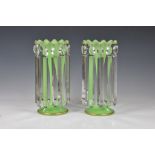A pair of Victorian green glass table lustres, the opaque, pale green glass vases with gilt,