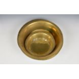 Four Guernsey brass Bachin, all of typical form, the largest measuring 18¾in. (47.6cm.) diameter,