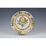 An Italian maiolica polychrome charger, 18th century, painted with a pomegranate within blue,