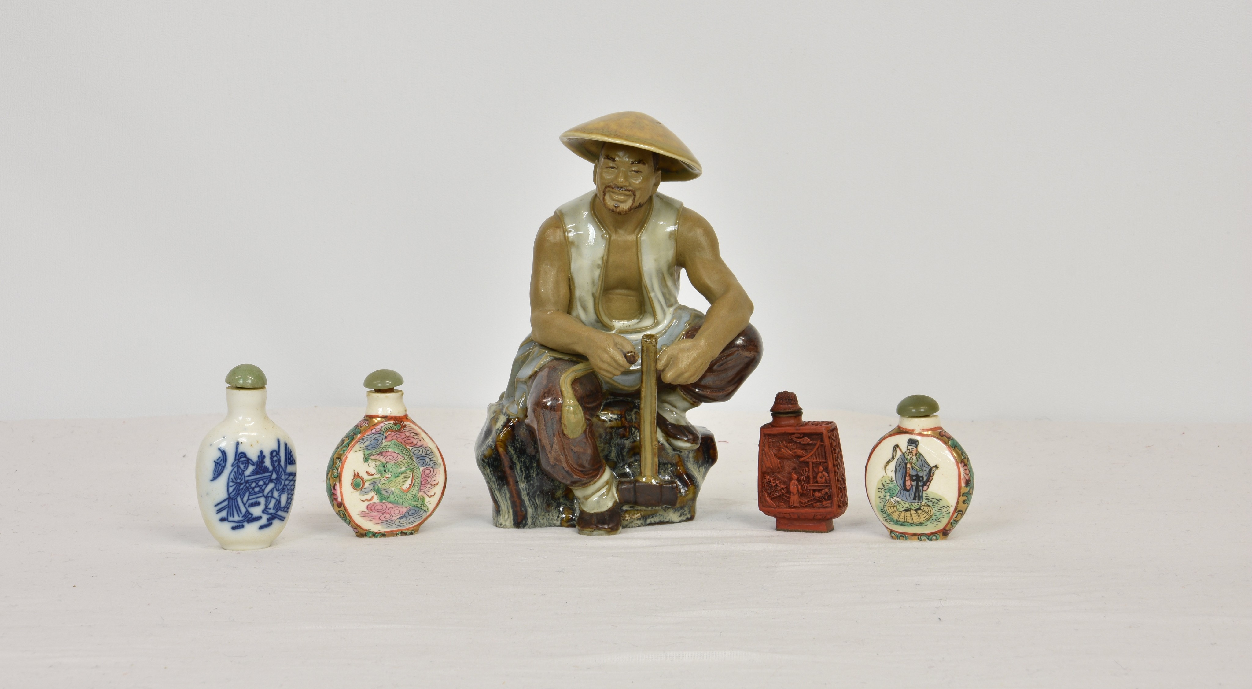 Four Chinese snuff bottles, three porcelain and one cinnabar lacquer, with stoppers, all with