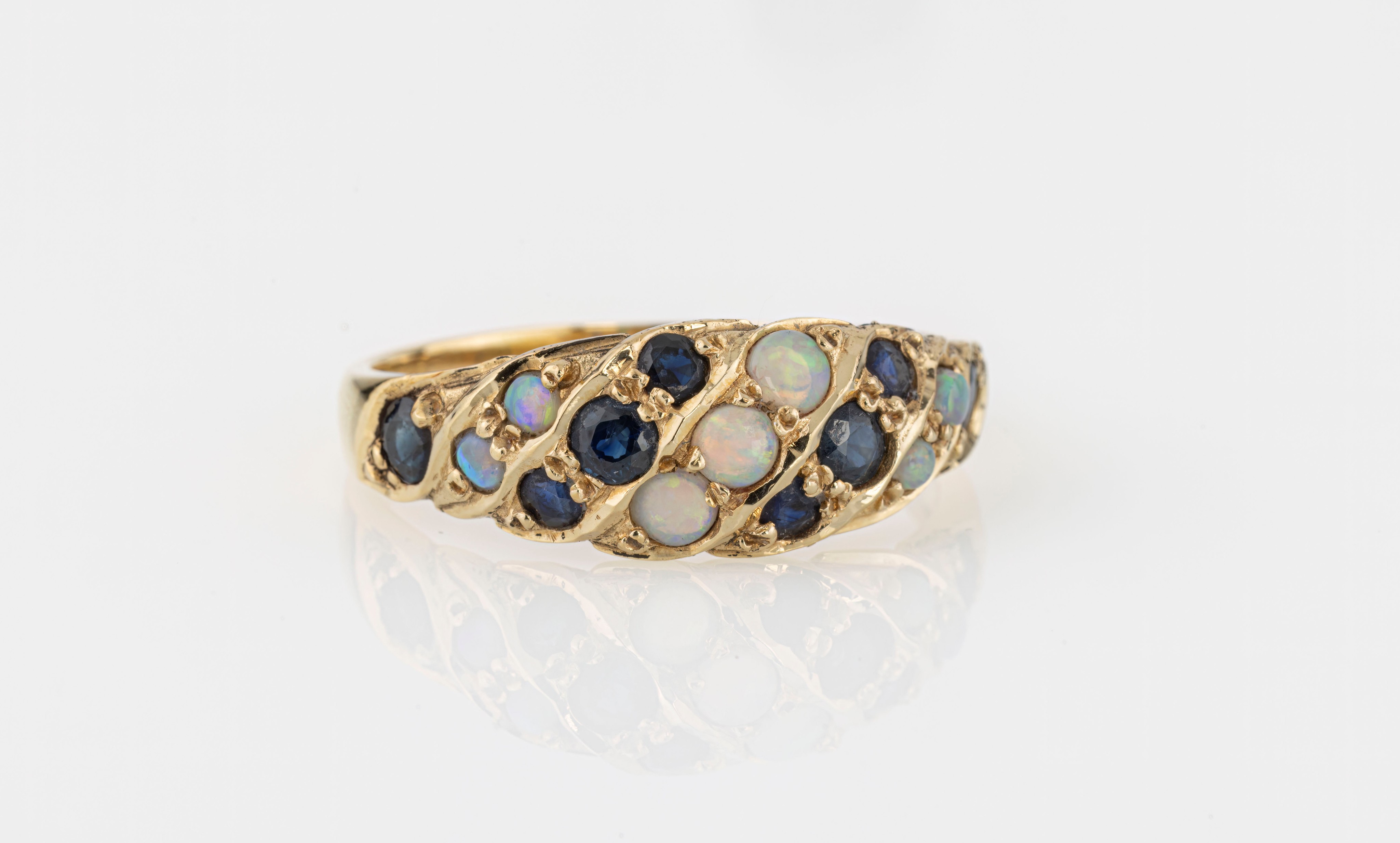 A 14ct yellow gold, opal and sapphire ring, the bright cut, domed shank diagonally set with