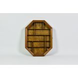 An octagonal wooden wall hanging display case, late 20th century, with side hinged glazed door and