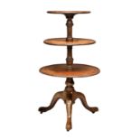 A George III mahogany and rosewood three-tier dumb waiter, on a tripod base with pointed pad feet