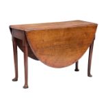 An 18th century oak dropflap dining table, the oval top opening on gatelegs, raised on turned