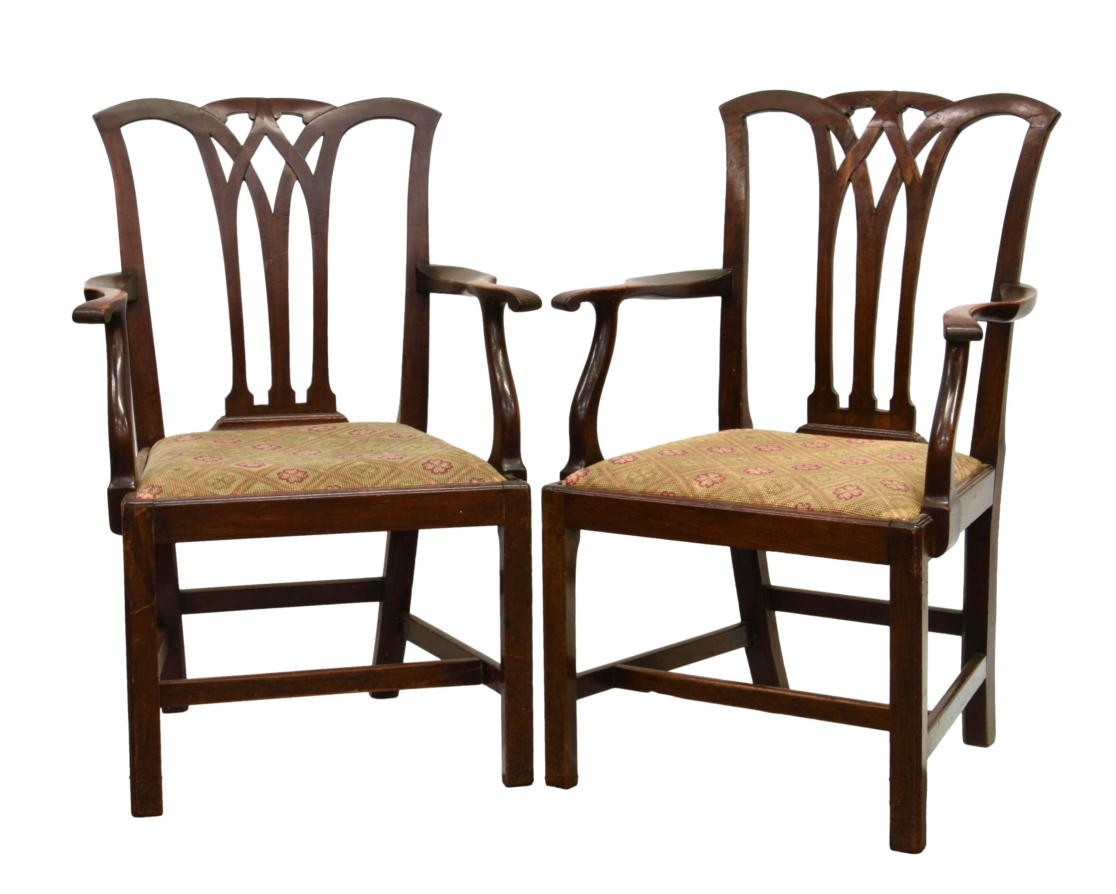 A pair of 18th century mahogany elbow dining chairs, with Chippendale style lattice backs over