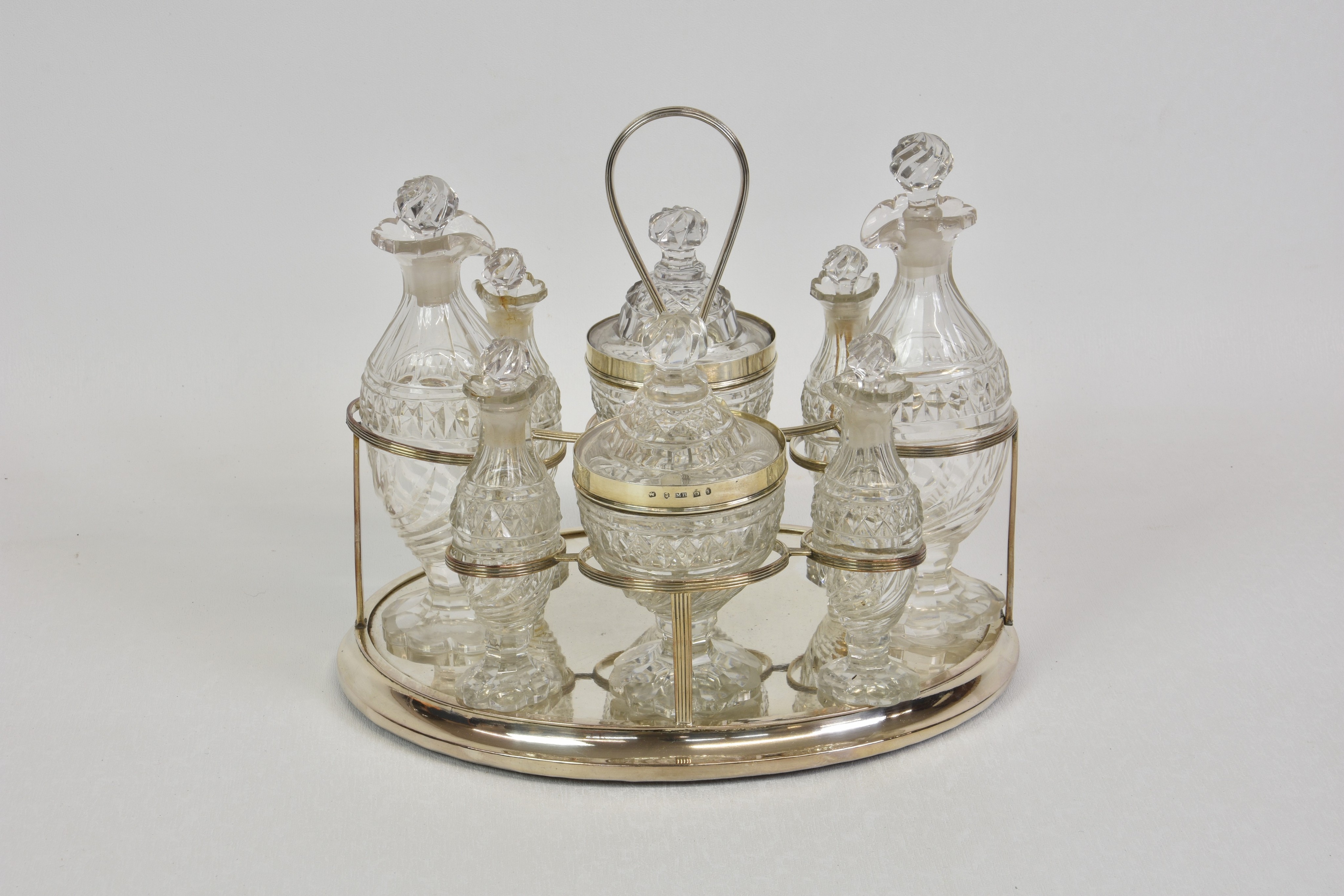 A George III white metal eight bottle cruet stand, with two silver-mounted lidded pots, Matthew