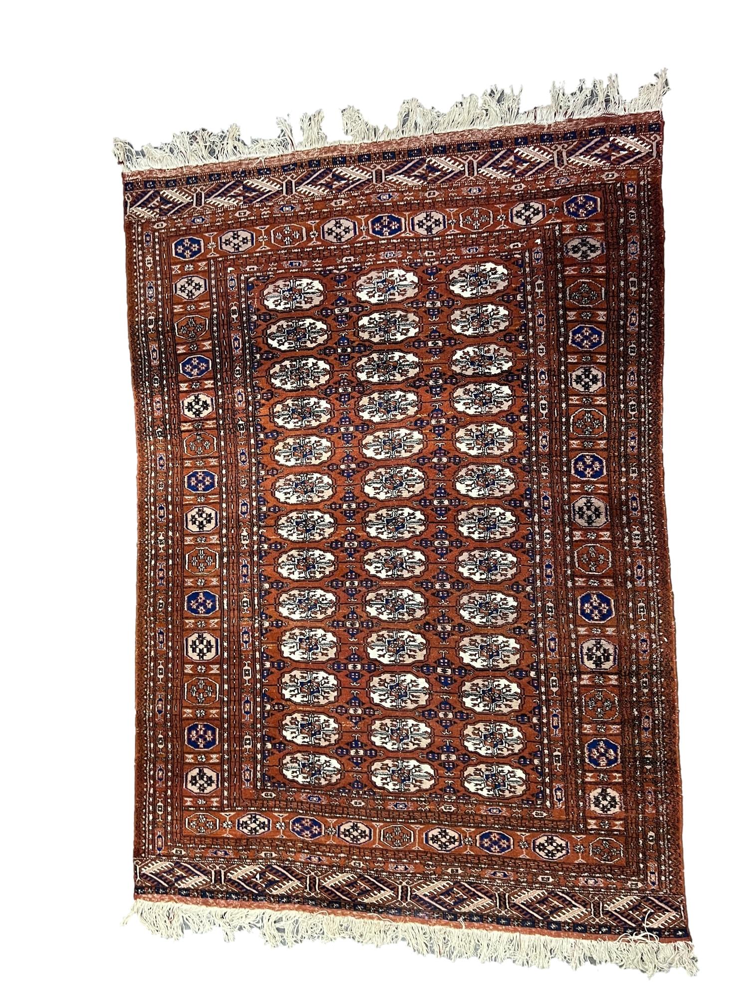 A Tekke Bokhara rug, on a red brick ground with three rows of thirteen elephants foot Guls separated