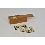 An early 20th century boxed complete 28 piece domino set, bone and ebony, with its original ‘Rules