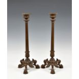 A pair of late 19th century patinated bronze Empire style candlesticks, with elongated tapering