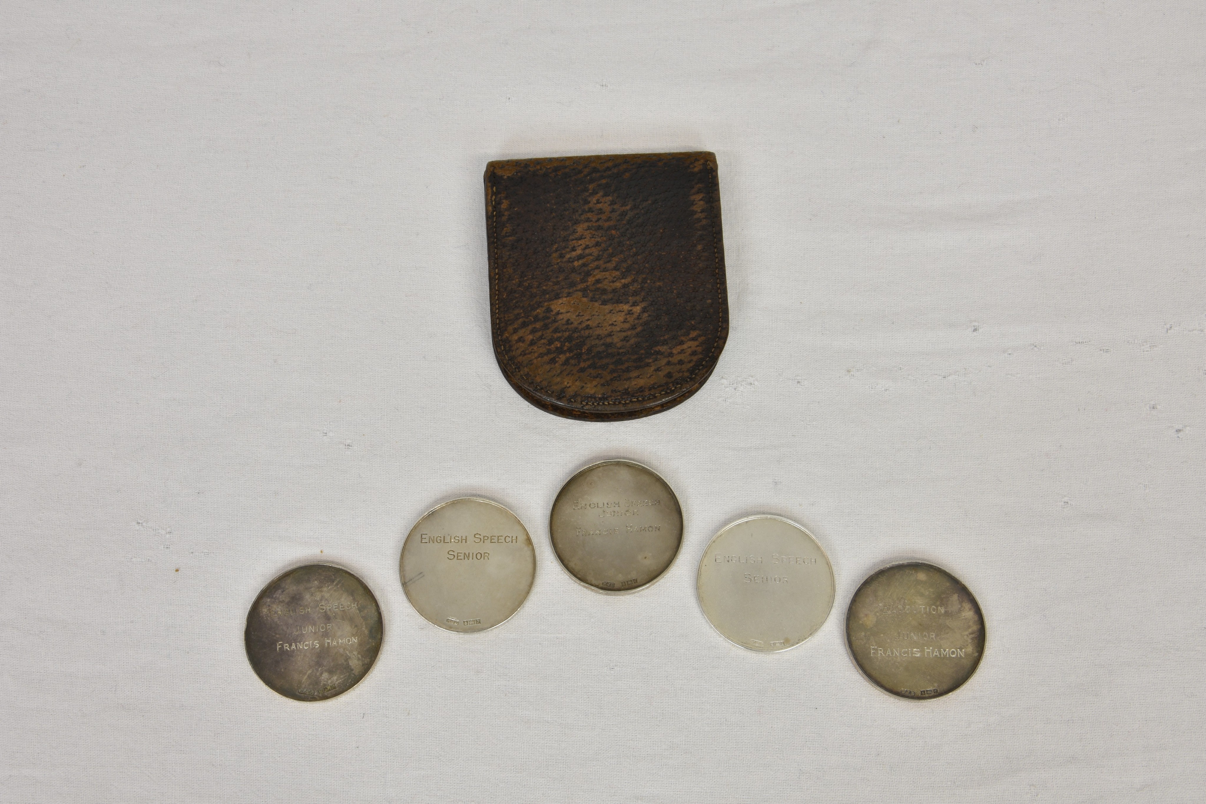 A leather pouch containing five silver Jersey Eisteddfod medals, William James Dingley,