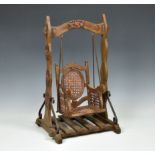 A painted wooden and rattan dolls swing seat, second half 20th century, the frame decorated with