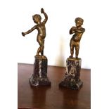 A pair of gilt bronze putti figures, one playing reed pipes and the other cymbals, with one arm