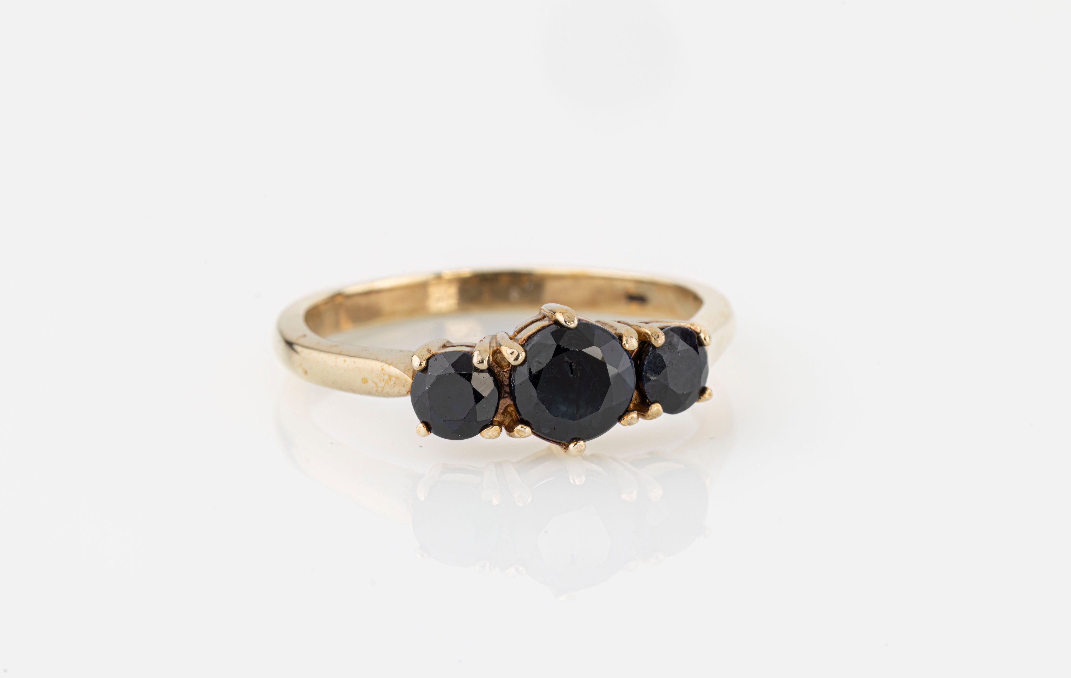 A 9ct yellow gold and sapphire three stone ring, with three graduated round cut sapphires, set S..