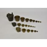 Two antique sets of bronze cup / bucket weights, early 19th century, probably German, the larger