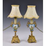 A pair of Continental porcelain and gilt metal mounted urn vases, later converted to electric