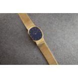 A Universal 18ct gold gentleman's wrist watch, 1980s, the dark blue rounded rectangular dial with