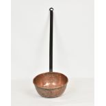 A large hammered copper and cast iron Black Butter ladle, overall length 36in. (91.4cm.) long, the