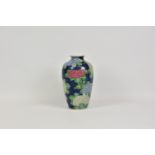 An Art pottery baluster vase, decorated with blue, pink and white hydrangea type flowers,