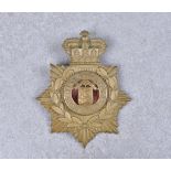 A Royal Guernsey Light Infantry brass helmet plate, bearing Crown, laurel and centred by insignia on