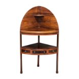 A George III mahogany corner washstand, with a high arched splash back and a central drawer to the