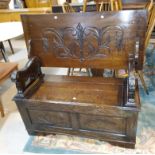 A carved oak monk's bench with lion arms, 101 cm