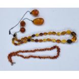 A necklace of butterscotch amber coloured beads and other similar costume jewellery