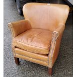 A tub shaped armchair in studded brown hide