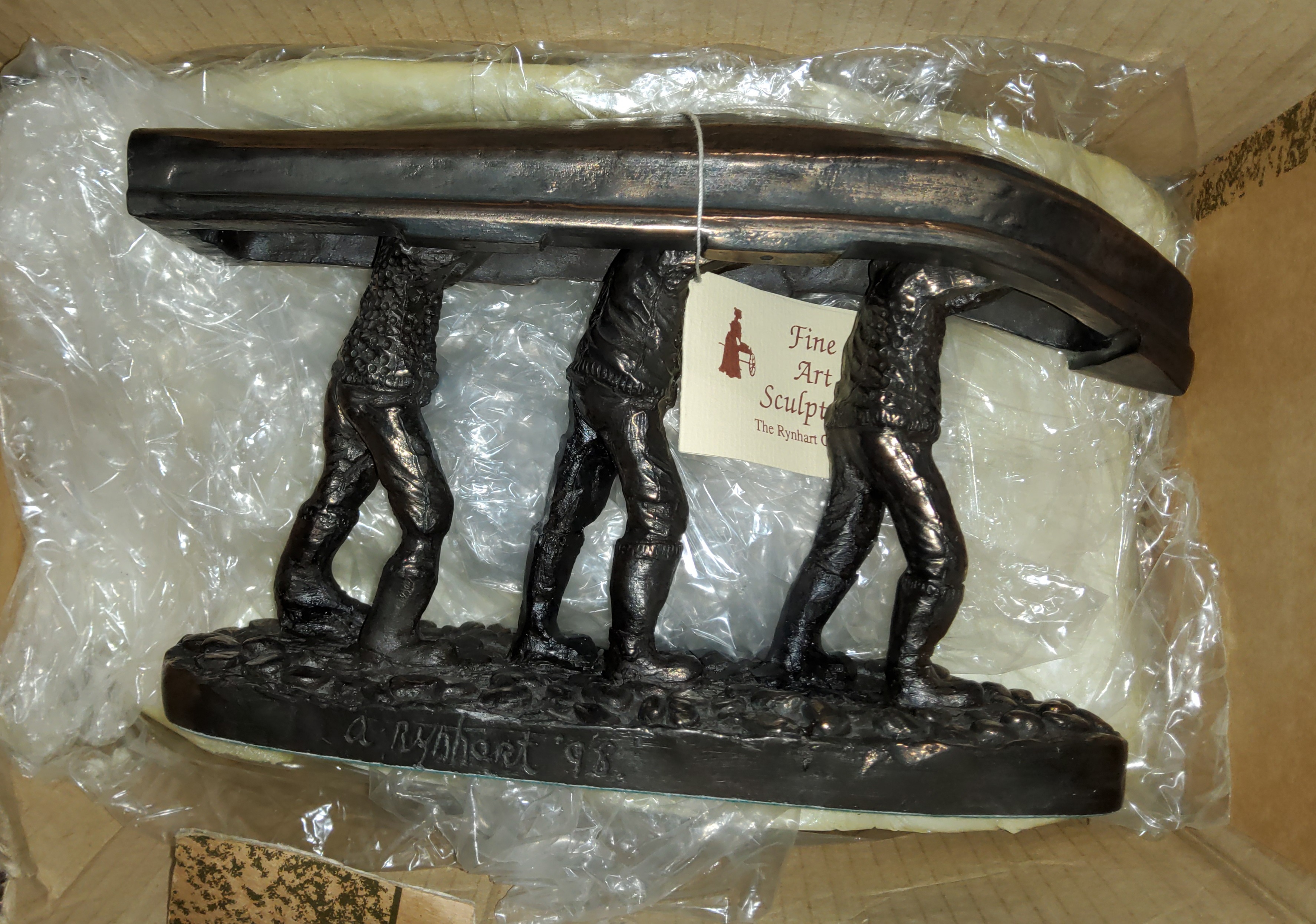 A 'The Rynhart Collection' 'Men of Aran' bronze effect sculpture of three men carrying a Canoe on