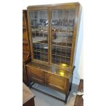 A 1920's oak traditional bookcase with leaded glass doors to upper section, 106 cm