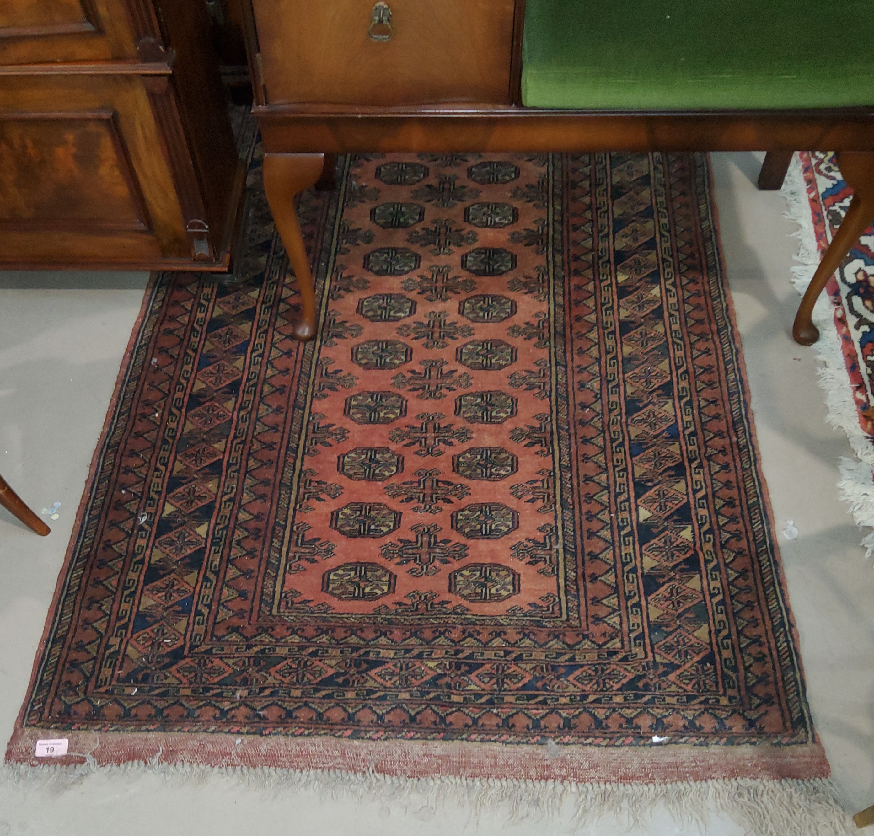 A mid 20th century rust ground hand knotted rug, with 2 rows of elephants foot motife to the