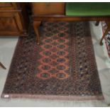 A mid 20th century rust ground hand knotted rug, with 2 rows of elephants foot motife to the