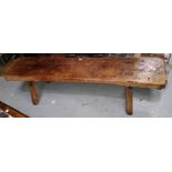 An 18th century rectangular distressed elm country made bench on chamfered square peg legs length