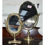 A brass Art Nuveau style oval mirror on stand & another similar mirror.