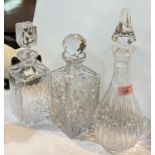 A baluster cut glass decanter with sliced decoration; 2 square cut glass decanters all with stoppers