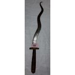 An unusual ceremonial knife with wooden carved and wire wrapped handle with snaking blade