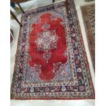 A 20th century red ground hand knotted Persian rug with floral medallion and borders, 184 x 122cm