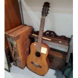 A vintage leather suitcase; a Spanish guitar; a small cupboard