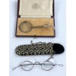 A cased pair of lorgnette; a pair of 19th century steel rimmed spectacles in ornate pierced metal
